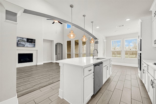 kitchen featuring visible vents, wood tiled floor, appliances with stainless steel finishes, a ceiling fan, and a sink