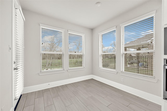 interior space with baseboards and wood finished floors