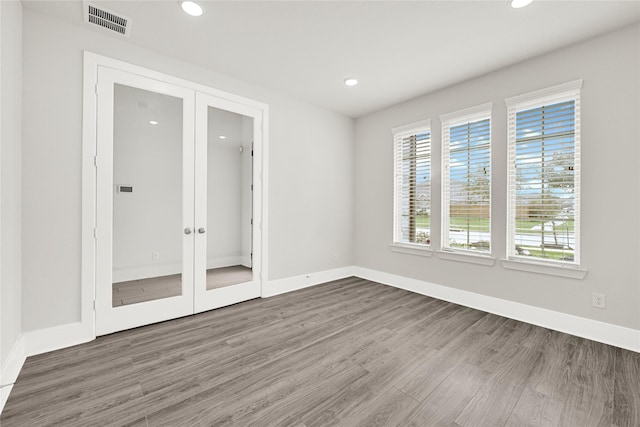 unfurnished room with wood finished floors, recessed lighting, french doors, and visible vents