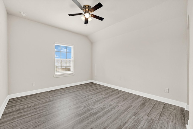 unfurnished room with baseboards, lofted ceiling, wood finished floors, and a ceiling fan