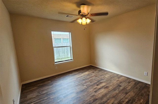 unfurnished room with a textured ceiling, baseboards, and dark wood-style flooring