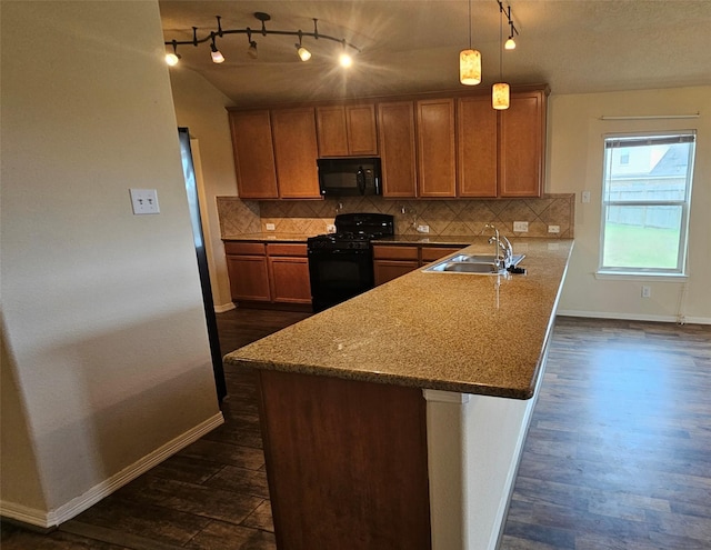 kitchen with hanging light fixtures, black appliances, brown cabinetry, and a sink