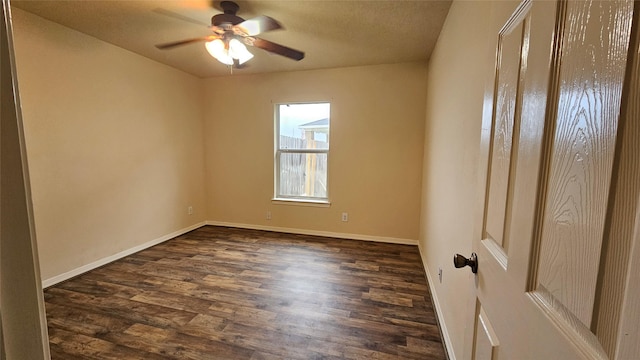 empty room with dark wood-type flooring, ceiling fan, and baseboards