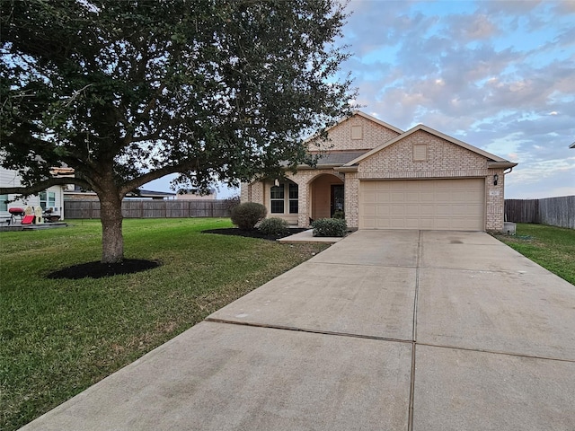 view of front of home featuring fence, a front lawn, concrete driveway, and brick siding