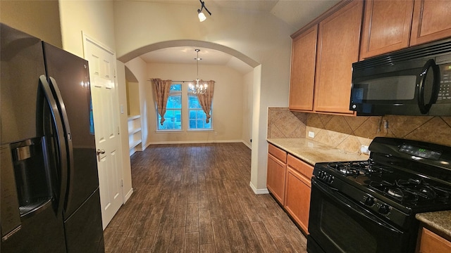 kitchen featuring arched walkways, dark wood-style flooring, tasteful backsplash, brown cabinetry, and black appliances