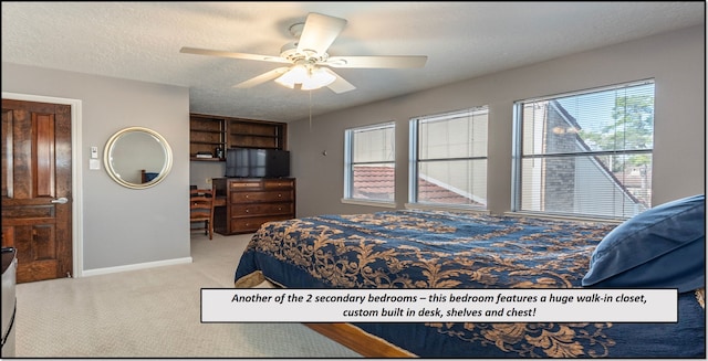 bedroom with ceiling fan, light colored carpet, and a textured ceiling