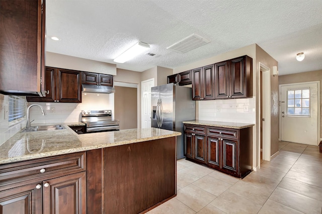 kitchen featuring sink, dark brown cabinets, stainless steel appliances, and light stone countertops