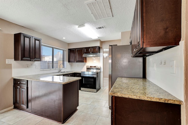 kitchen with sink, appliances with stainless steel finishes, dark brown cabinetry, light stone counters, and decorative backsplash