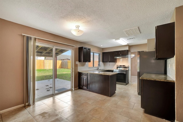 kitchen featuring appliances with stainless steel finishes, sink, decorative backsplash, dark brown cabinetry, and a textured ceiling