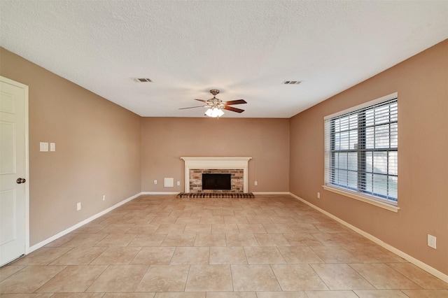 unfurnished living room featuring ceiling fan, light tile patterned floors, a textured ceiling, and a fireplace