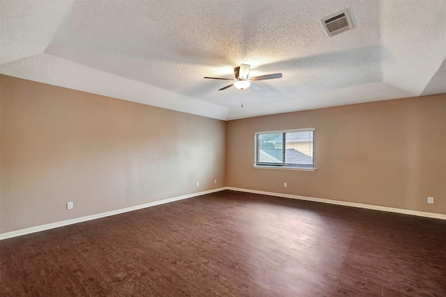 empty room with lofted ceiling, dark hardwood / wood-style floors, a textured ceiling, and ceiling fan