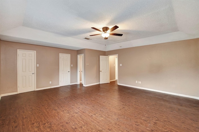 empty room featuring a textured ceiling, dark wood-type flooring, and ceiling fan