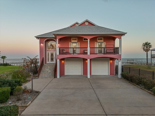 view of front of house with a garage and a water view