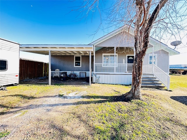 rear view of house with a yard and covered porch