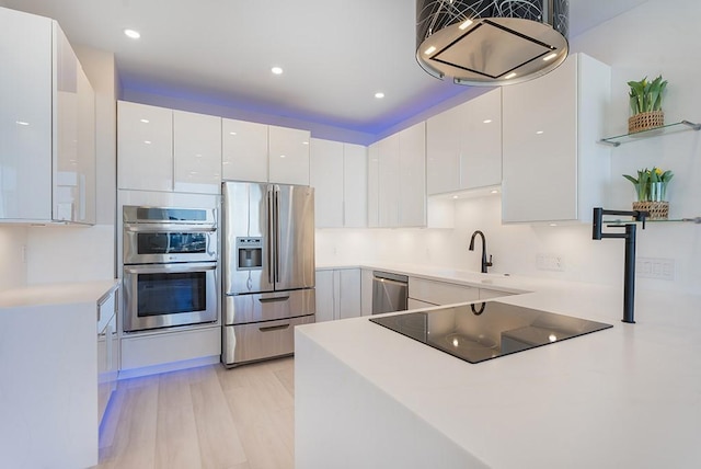 kitchen featuring appliances with stainless steel finishes, sink, light wood-type flooring, and white cabinets