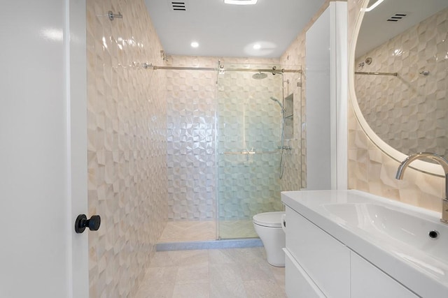 bathroom featuring vanity, tiled shower, and toilet