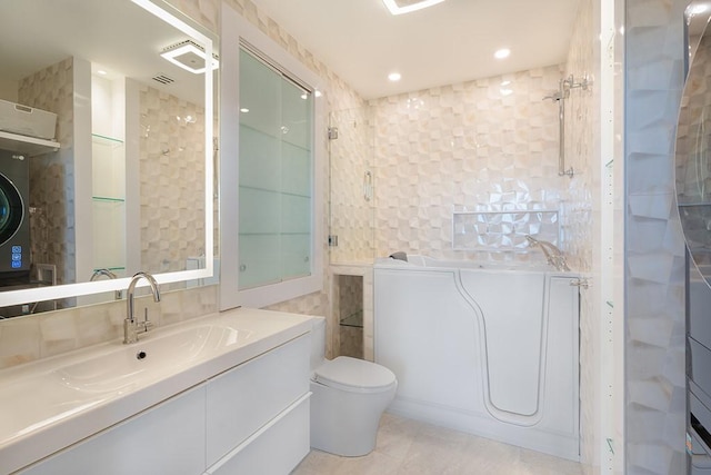 bathroom featuring tile patterned floors, vanity, toilet, and tile walls