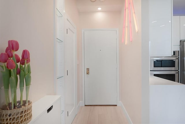 corridor with light hardwood / wood-style flooring