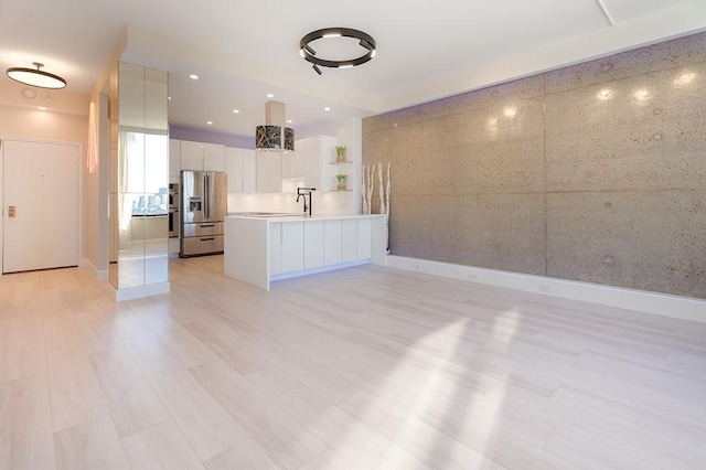 kitchen featuring white cabinetry, sink, light hardwood / wood-style floors, and stainless steel refrigerator with ice dispenser