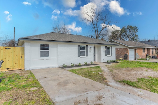 single story home featuring brick siding, roof with shingles, and fence