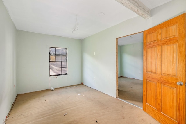 unfurnished room featuring beam ceiling