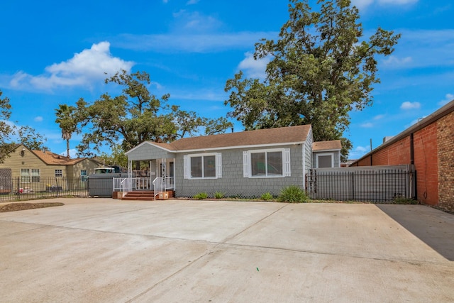 view of front of home with concrete driveway and fence