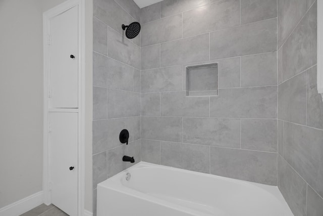 full bath featuring baseboards and tub / shower combination