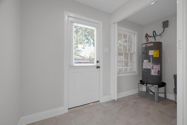 entryway featuring light tile patterned floors, baseboards, and electric water heater