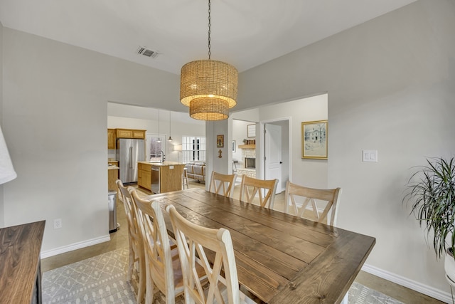 dining area with an inviting chandelier and sink