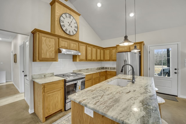 kitchen with stainless steel appliances, hanging light fixtures, sink, and a kitchen island with sink