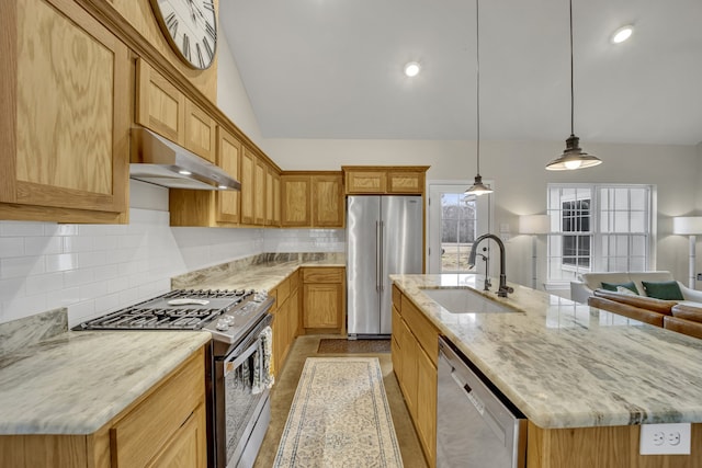 kitchen featuring sink, stainless steel appliances, hanging light fixtures, and a center island with sink