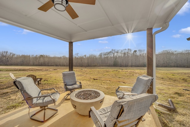 view of patio / terrace featuring a rural view, ceiling fan, and an outdoor fire pit