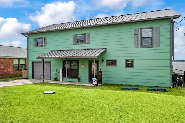 308 Lakeshore S, Onalaska, TX 77360 - back of property featuring concrete driveway, a yard, a standing seam roof, and an attached garage