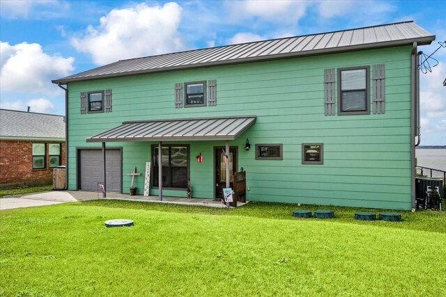 308 Lakeshore S, Onalaska, TX 77360 - rear view of property with a standing seam roof, an attached garage, driveway, and a yard