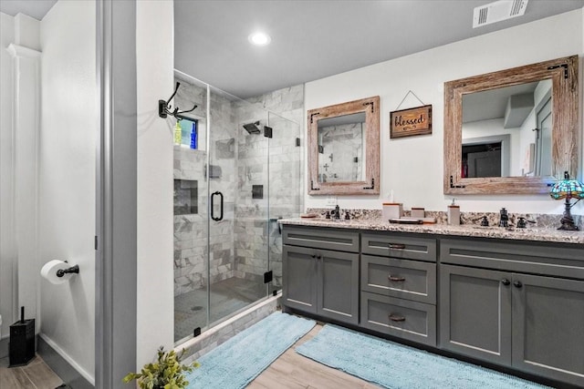 308 Lakeshore S, Onalaska, TX 77360 - bathroom with a stall shower, visible vents, a sink, double vanity, and wood finished floors