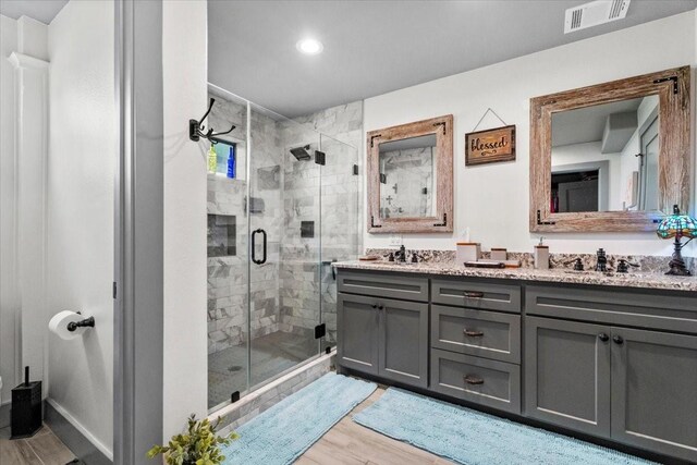 308 Lakeshore S, Onalaska, TX 77360 - bathroom featuring a stall shower, wood finished floors, double vanity, and recessed lighting