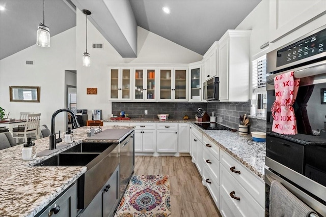 308 Lakeshore S, Onalaska, TX 77360 - kitchen featuring a sink, stainless steel appliances, light wood-type flooring, glass insert cabinets, and white cabinets