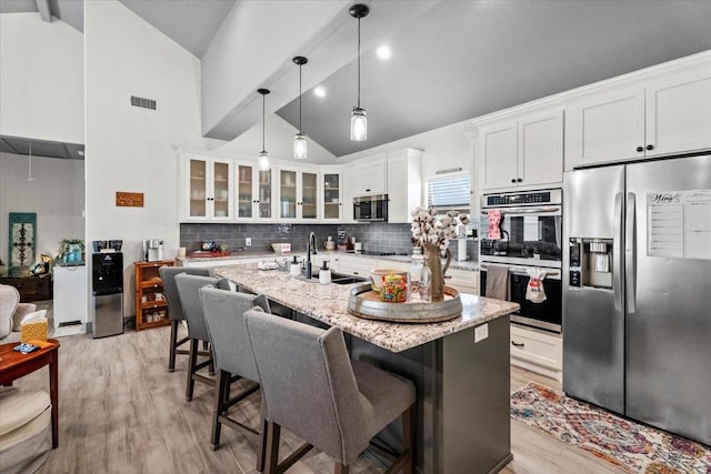 308 Lakeshore S, Onalaska, TX 77360 - kitchen featuring glass insert cabinets, a sink, visible vents, backsplash, and appliances with stainless steel finishes