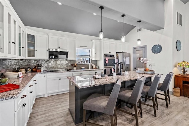 308 Lakeshore S, Onalaska, TX 77360 - kitchen featuring a sink, light wood-style flooring, tasteful backsplash, and appliances with stainless steel finishes