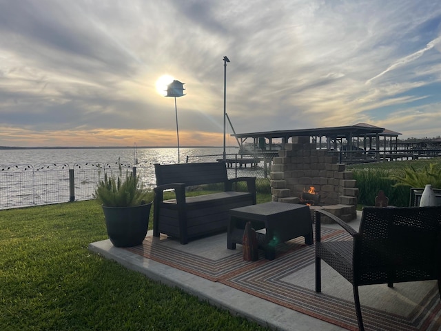 308 Lakeshore S, Onalaska, TX 77360 - wooden terrace featuring a water view, an outdoor living space with a fireplace, fence, and a lawn
