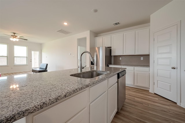 kitchen featuring stainless steel appliances, sink, and white cabinets