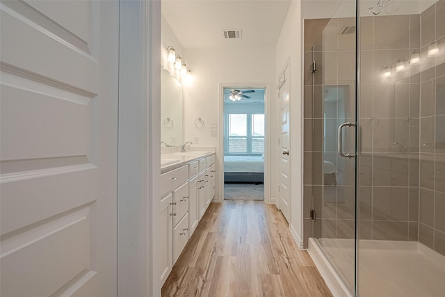 bathroom featuring hardwood / wood-style flooring, vanity, ceiling fan, and a shower with shower door