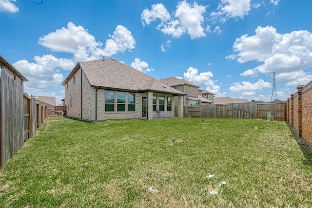 rear view of property with a yard