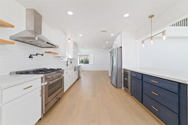 kitchen with pendant lighting, range hood, wine cooler, white cabinets, and stainless steel appliances