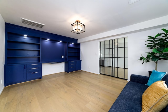 interior space with built in desk and light hardwood / wood-style floors