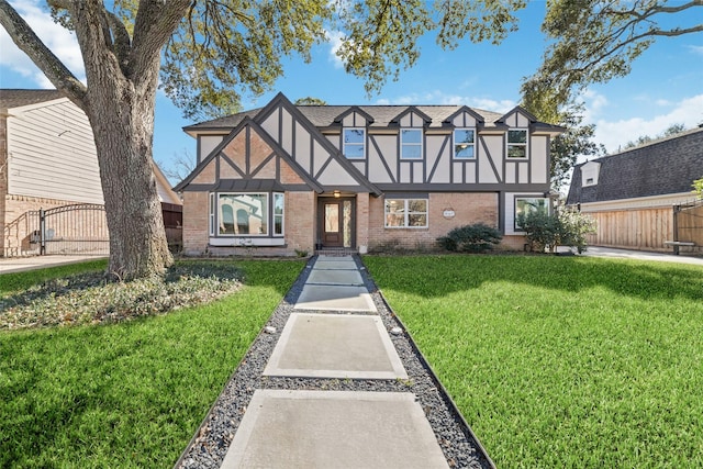 tudor-style house featuring a front lawn