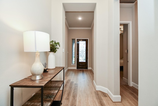 entrance foyer featuring ornamental molding and light hardwood / wood-style flooring