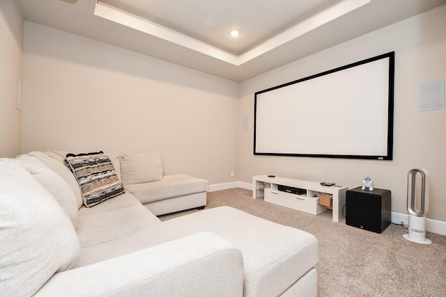 home theater room featuring a tray ceiling and carpet floors