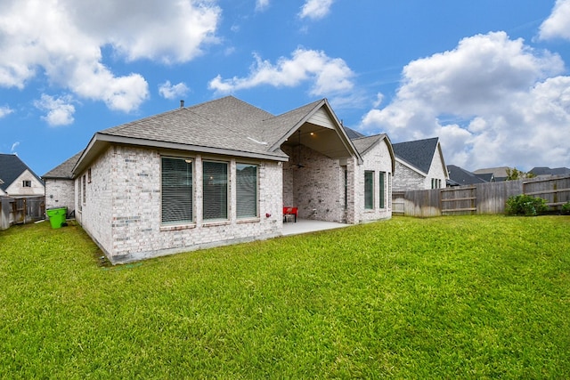 rear view of property featuring a yard and a patio