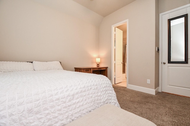 bedroom with ensuite bathroom and light colored carpet